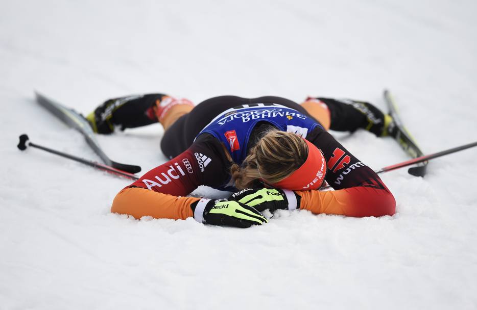 La tedesca Denise Herrmann, stremata dopo la gara sprint di sci nordico, si lascia andare nella neve. Siamo a Falun in Svezia, durante i Campionati Mondiali (Getty Images)